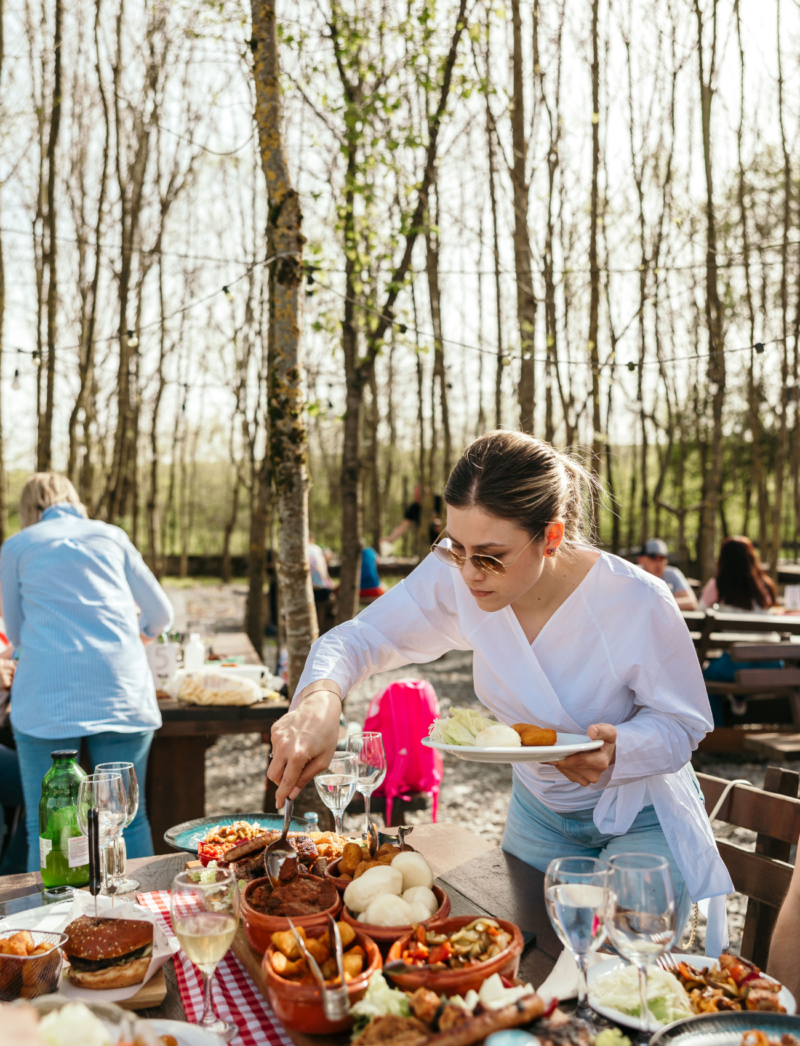 Konobarica poslužuje Moslavački stol u dvorištu restorana